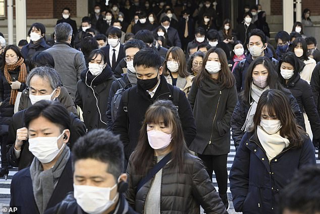 Commuters wear masks outside Tokyo Station in Tokyo, Japan on Friday, Jan. 20, 2023