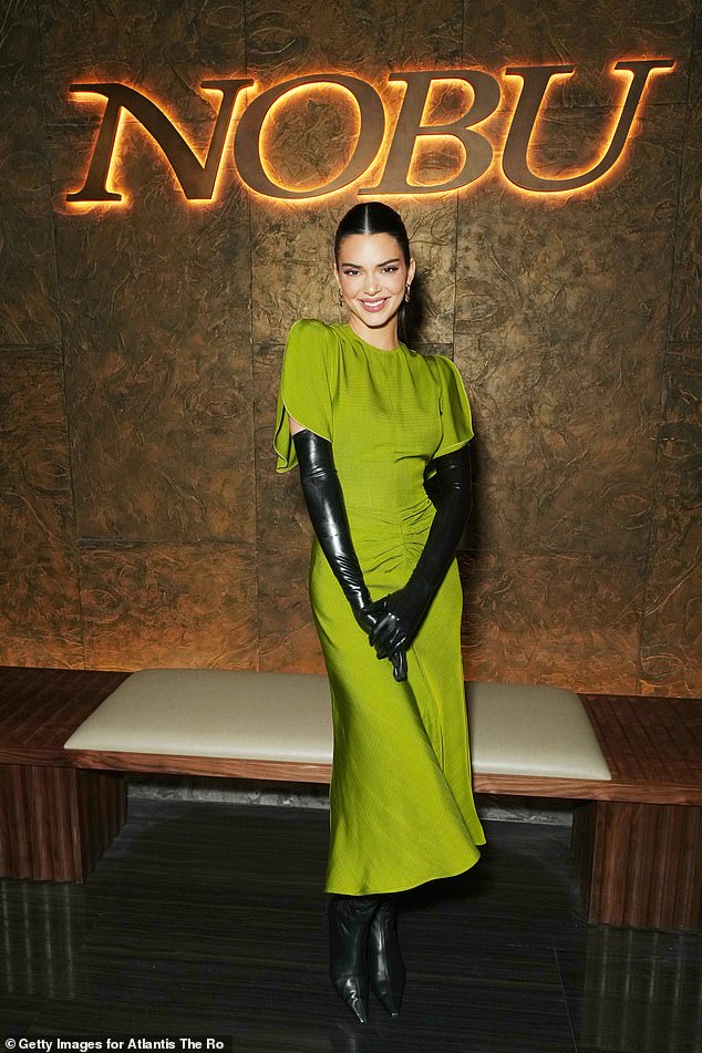 Gorgeous: Kendall Jenner wore an eye-catching green bodycon dress paired with sleek black gloves for the event