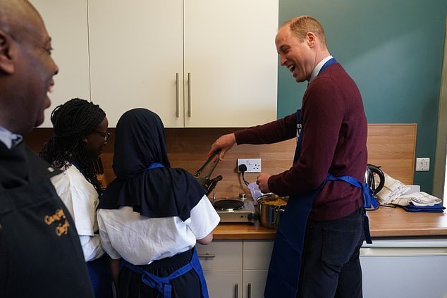 Prince William is pictured cooking with young carers at the Together as One center in Slough today.