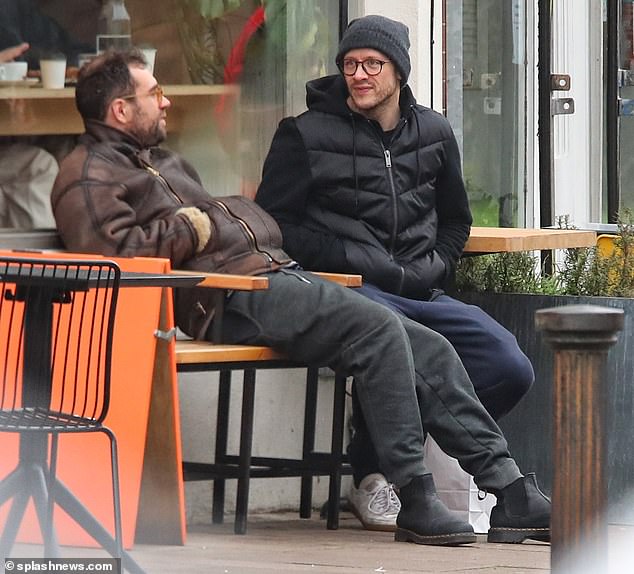 Day out: Former strictly pro Kevin Clifton looked casual as he ate and sat outside a cafe with a friend in London on Saturday