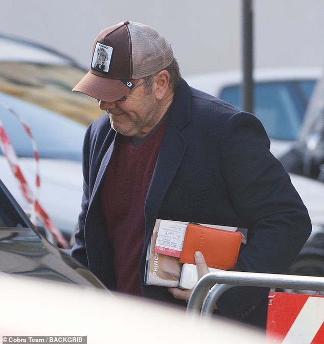 Outing: Kevin Spacey kept a low profile when he headed out to Rome, Italy, on Thursday with a copy of Prince Harry's book Spare.
