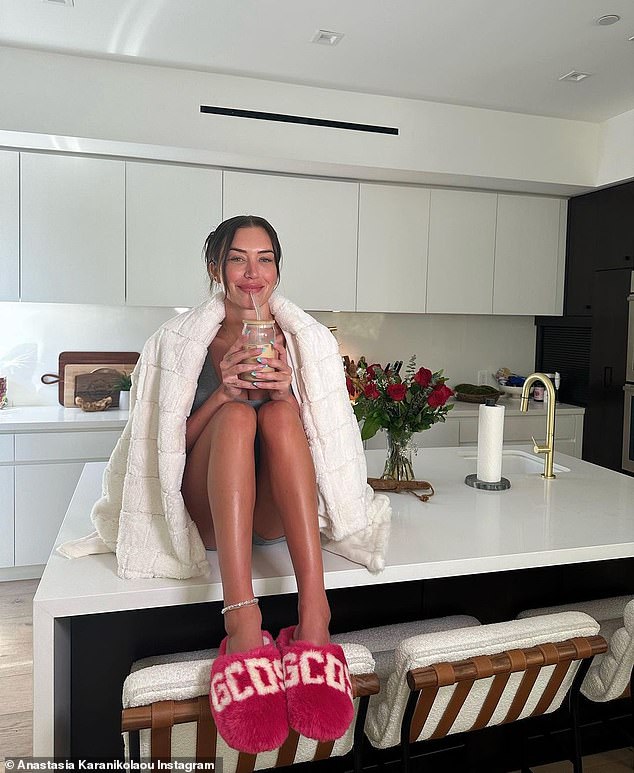 Cozy: Anastasia Karanikolaou, 25, shared some fun photos of herself at her kitchen counter wrapped in a blanket from her Stassie by Anastasia Karanikolaou line on Tuesday