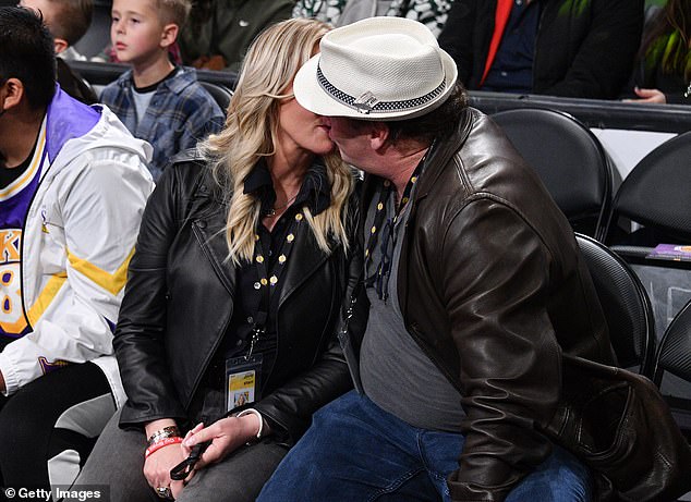 Tender moment: Los Angeles Lakers owner Jeanie Buss and her fiancé Jay Mohr kissed sweetly at a home game Monday after publicly announcing their engagement last month.