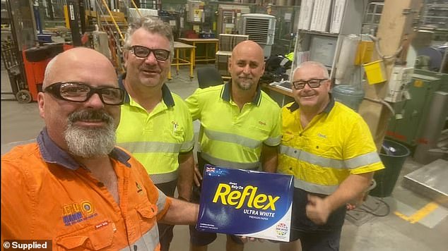 Trevor Patton (left) and his co-workers at the Maryvale paper mill are shown with the last ream of Reflex white paper produced there.