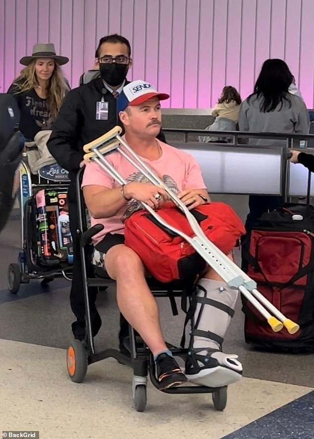 Luke Hemsworth, the oldest of the Hemsworth brothers, was seen using a wheelchair and crutches while traveling through LAX airport on Wednesday.