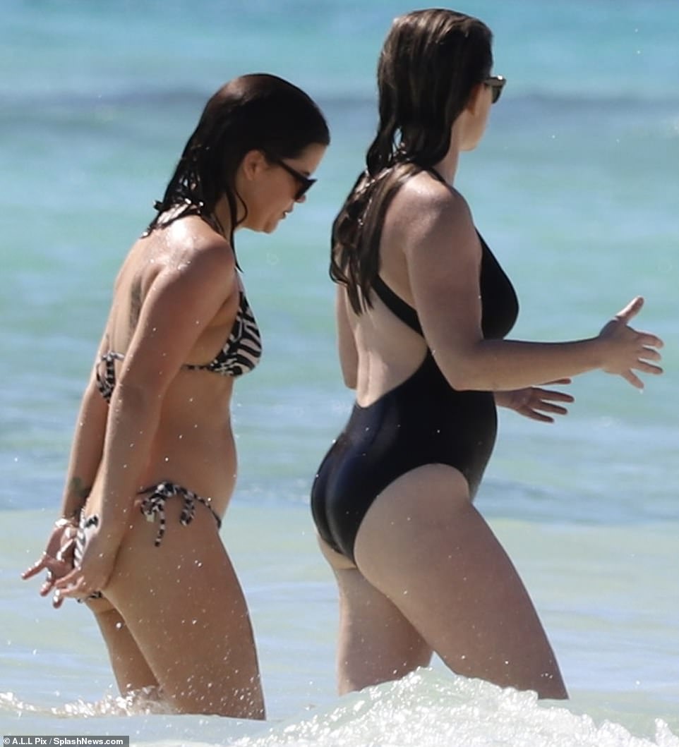 Here they go: She was accompanied by a friend in black overalls for her last day at the beach, during which the two could be seen wading through the waves together.