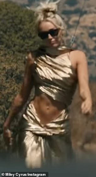 The drama blossoms: In Miley's music video for her hit song Flowers, which not-so-subtly roasts ex-husband Liam Hemsworth, she struts through the Hollywood Hills in a skintight gold dress.