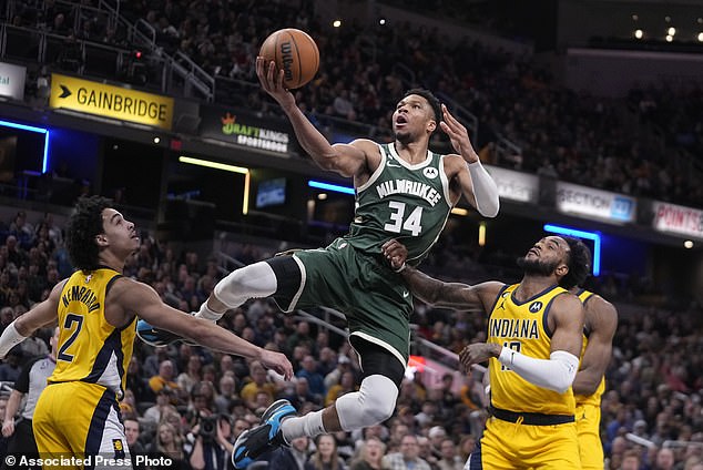 Giannis Antetokounmpo (34) shoots at Andrew Nembhard and Oshae Brissett (12)