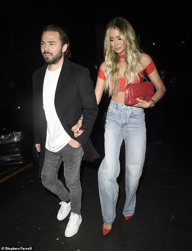 Racy: Olivia Attwood braved the cold in a little red top as she walked arm in arm with fiance Bradley Dack leaving The Ivy in Manchester on Sunday