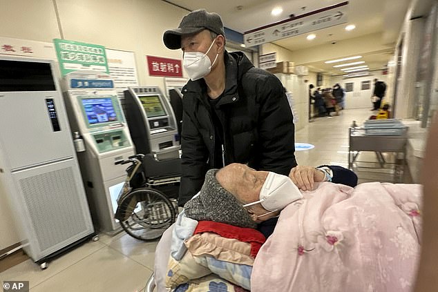 An elderly patient is pushed along a hospital emergency room corridor in Beijing, where covid infections are peaking.