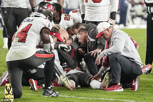 Russell Gage is examined on the pitch as his teammates look on in amazement during Monday's game.