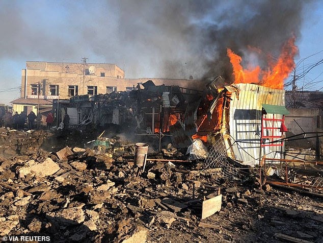 A building burns at a site of a market hit by Russian missiles, amid Russia's attack on Ukraine, in the town of Shevchenkove