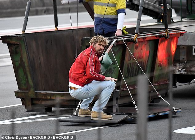 Ryan Gosling's new movie The Fall Guy took over the Sydney Opera House to film scenes on Sunday, halting the flow of traffic on one of the city's busiest motorways.  Pictured: Ryan Gosling filming on the Sydney Harbor Bridge on Sunday