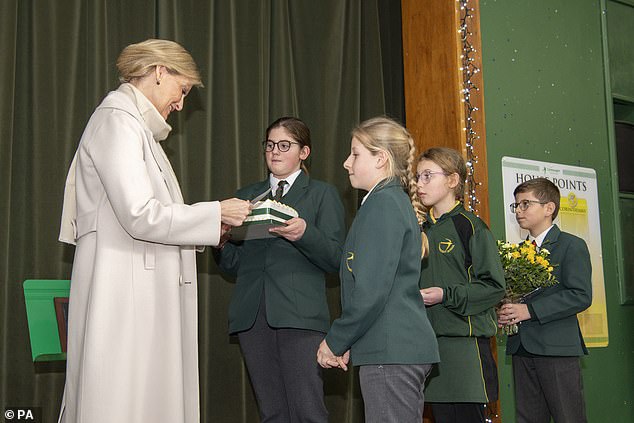 The Countess of Wessex smiled as Surrey schoolchildren presented her with a cake this afternoon ahead of her 58th birthday tomorrow.