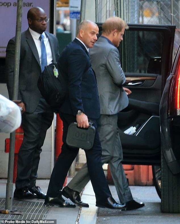 Prince Harry is seen on Monday leaving his Manhattan hotel and heading to record an episode of The Stephen Colbert Show, accompanied by a guard armed with a safe with a Glock pistol.