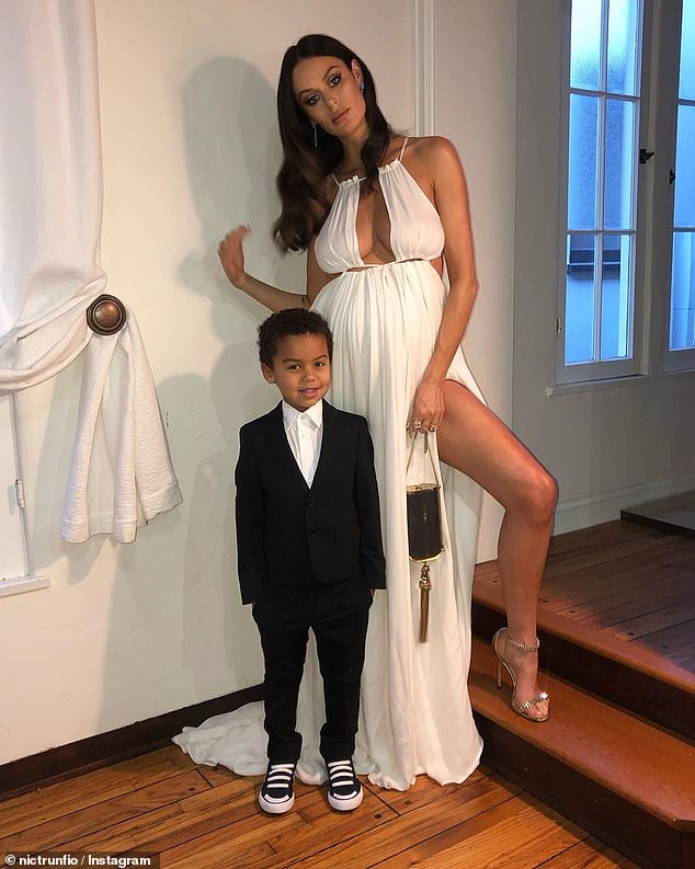 Nicole Trunfio, 36, was hard at work on Saturday putting the finishing touches on her son Zion's amazing Minecraft birthday cake ahead of his eighth birthday.  In the photo: Nicole with her son Zion