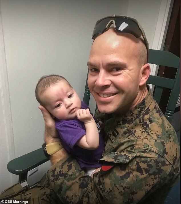 Marine Major Joshua Mast is seen with 'Baby L', the Afghan war orphan he adopted.  Relatives who had been raising the girl accused him of taking her without permission