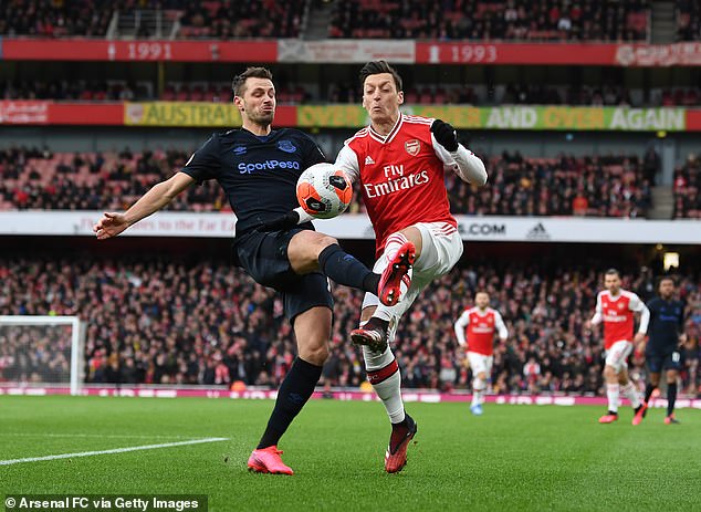 Arsenal's Mesut Ozil challenges Everton's Morgan Schneiderlin for the ball in the English Premier League in 2020