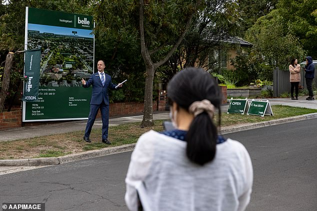 Australians on the average full-time salary have seen their borrowing capacity drop by $133,000 in just nine months and another rate hike will make matters worse (a Melbourne auction in April 2022 pictured)