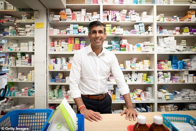 Ready with a remedy: Rishi Sunak behind the counter of what was the family pharmacy