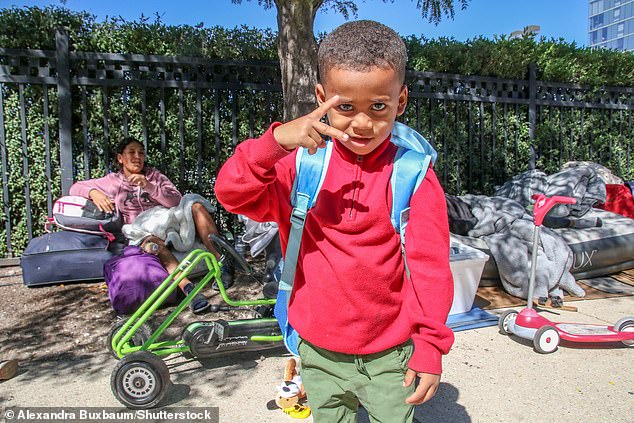 A migrant child poses outside the 18th District Police Station on Chicago's North Side on Wednesday