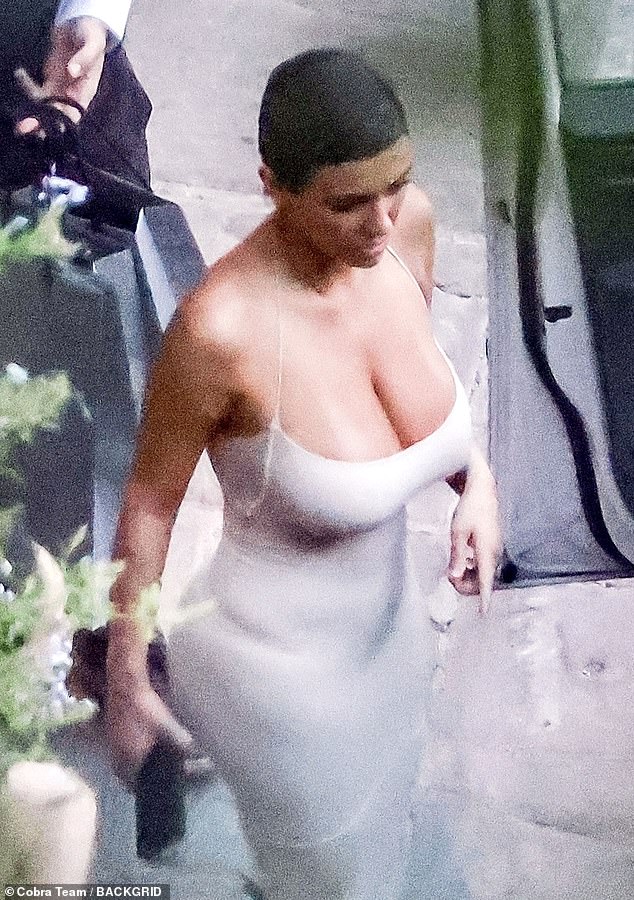 Busty: The 46-year-old rapper's new muse, 28, showed off her ample cleavage in a low-cut form-fitting white slip dress as she entered the shop, which was closed to the public