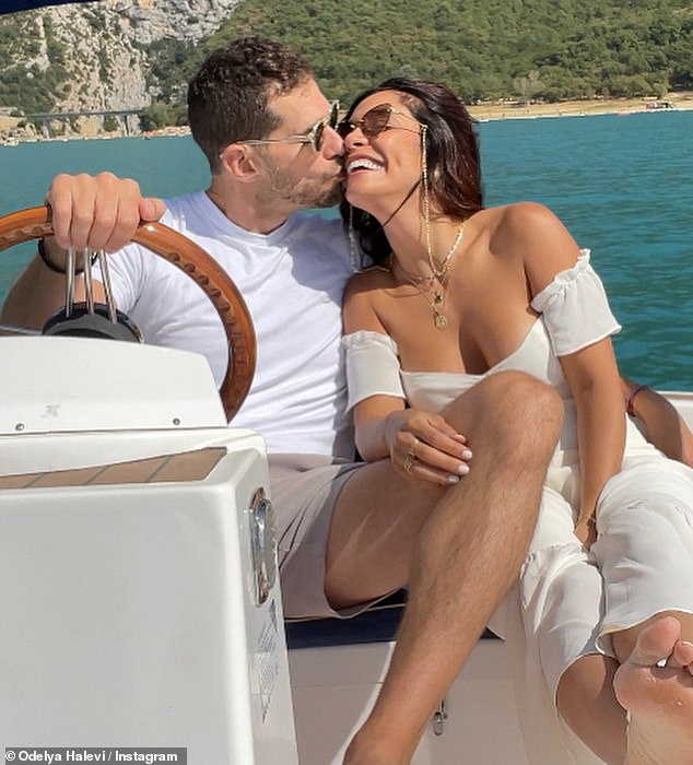 Sweet: The broker gave Odelya a kiss behind the wheel of the boat