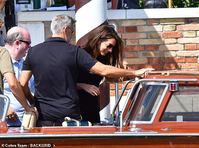 Happy: Amal appeared in good spirits giggling as she boarded the boat