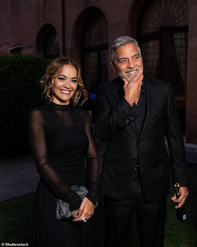 Looking good: George looked typically dashing in a black suit, which he wore with a slightly unbuttoned navy blue shirt, as he chatted with Rita Ora