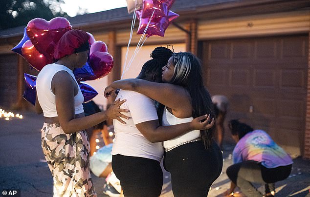 Friends comfort each other during a private candlelight vigil on Friday, August 25, 2023 in Columbus