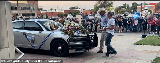 Her patrol car was decorated with flowers from colleagues and friends during the vigil