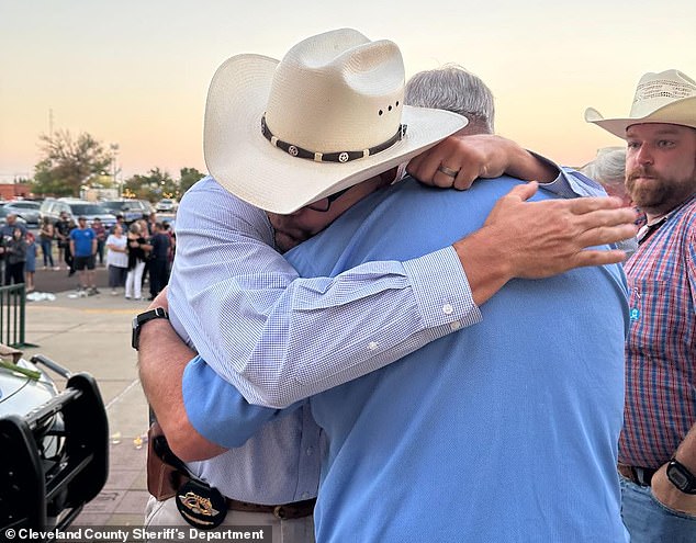 Amason (left) is comforted by a colleague during the vigil.