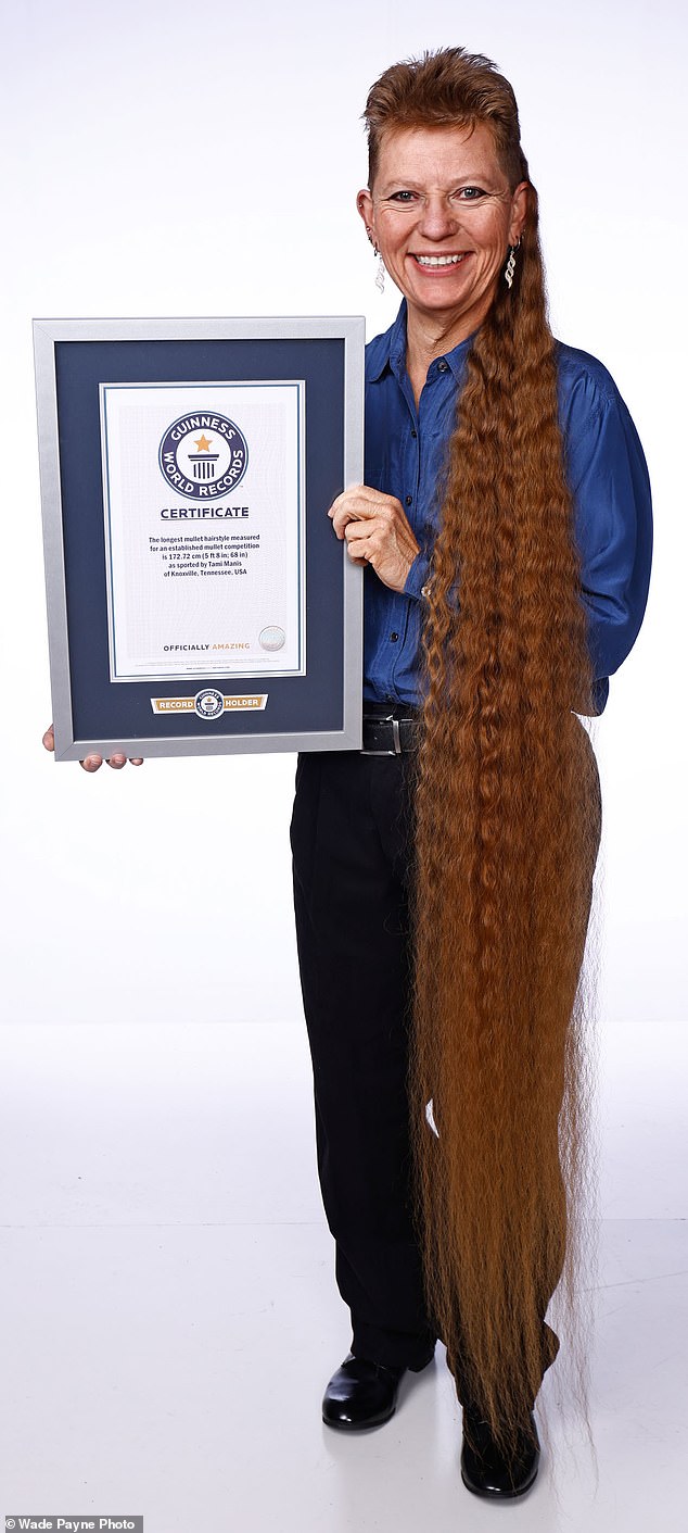 Manis beams as she holds up her certificate issued by Guinness World Records for the world's longest competitive mullet for a woman