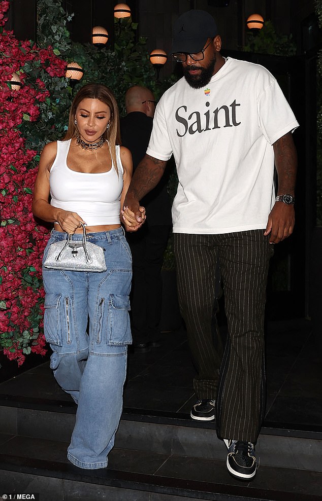 Keeping it casual, the basketball player stepped out in pinstripe pants and black trainers, which he paired with a white T-shirt with the words 