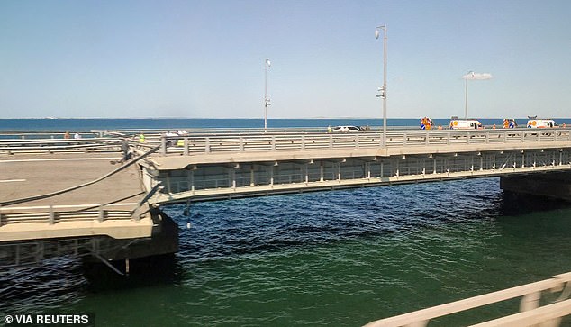 A view through a train window shows the section of a road that splits and slopes to one side after an alleged attack on the Crimean Bridge, July 17