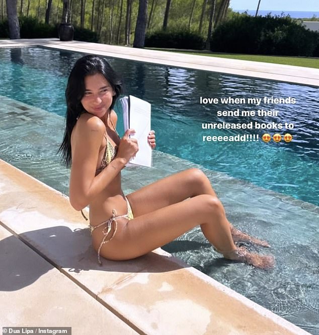 Downtime: Dua showed off her enviable figure as she lounged poolside in a gold two-piece suit and read her friend's unreleased book