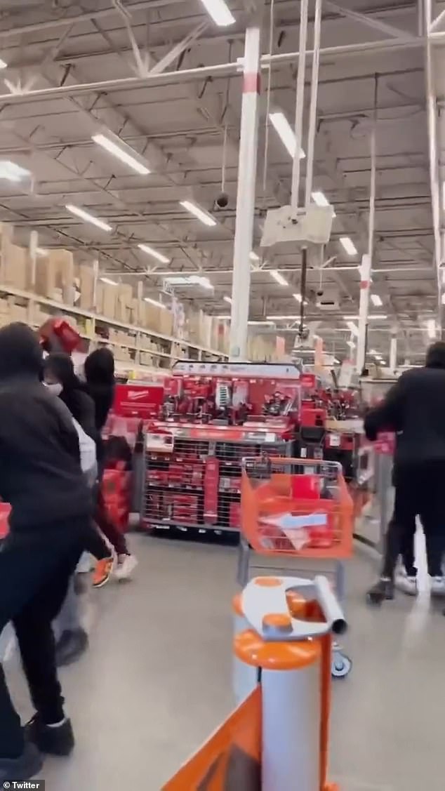 One of the bold thieves, in a gray hoodie, was seen wrestling an employee's shopping cart while the others loaded a second.