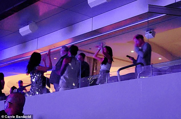 Prince Harry (right) didn't exactly look thrilled as he stared at his phone last night on the first night of Beyoncé's California Renaissance tour.  However, Meghan (center) was seen dancing all night long