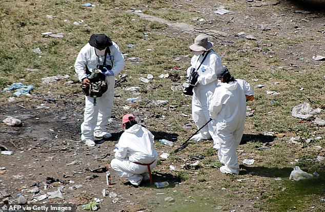 Forensic investigators search for human remains beneath a garbage-strewn hillside in the densely forested mountains on the outskirts of Cocula, Mexico, on Oct. 28, 2014