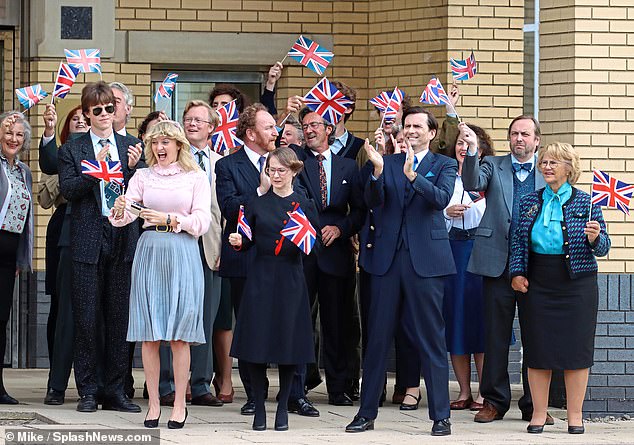 In our photos, Lord Baddingham is accompanied by flag-waving Corinium employees as Mrs Thatcher, played by an unknown actress, visits their headquarters