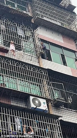 The neighbor also tries to reach the girl.  Fortunately, despite the rain, the child was released and led safely back through the window, without serious injury