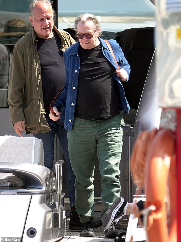 Out and about: The Canadian resident wore his gray hair tied up in a ponytail, shielding his eyes with sunglasses and carrying his belongings in a red leather backpack