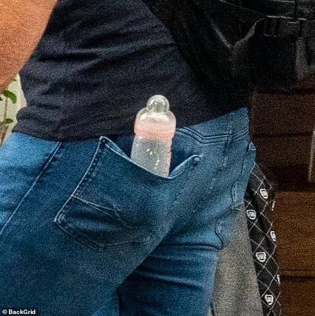 Prepared: The sports star also seemed to find a new place to keep the baby milk, as he managed to secure the bottle in the back pocket of his jeans