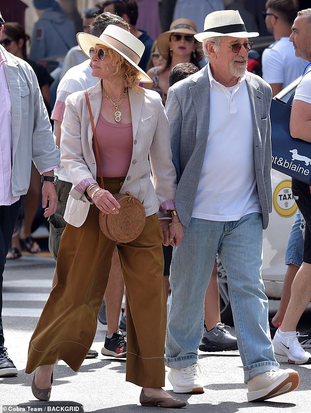 Dressed in a smart gray jacket, jeans and a cream fedora hat, the film director looked relaxed when he and his wife arrived in the picturesque harbor town.