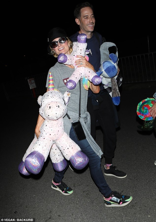 Prize winners!  The two lovebirds, who tied the knot in November 2021, were seen holding adorable stuffed toys, such as unicorns, that they won by playing games at the event