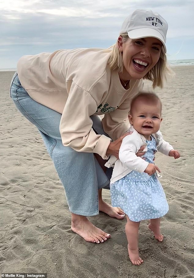 Happy: Mollie looked happier than ever as she spent time with her adorable little girl, who flashed a wide smile as she fell in love on the beach