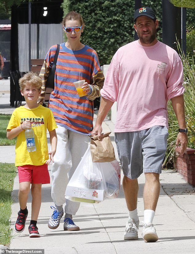 Her look: On the weekend outing, the mother of one child wore a baggy orange and blue horizontally striped shirt