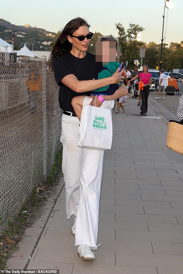 Precious cargo!  The Chicago-born, St. Louis-raised 31-year-old held the two-year-old boy tight at the Boys & Girls Club benefit, which requires all guests under 18 to be accompanied by a chaperone 21 or older.