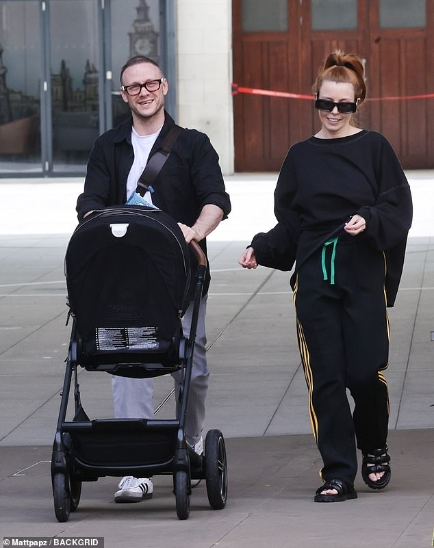 On the road: Kevin looked beaming and cheerful as he pushed their daughter along in the pram while hauling a £1,230 Gucci diaper bag