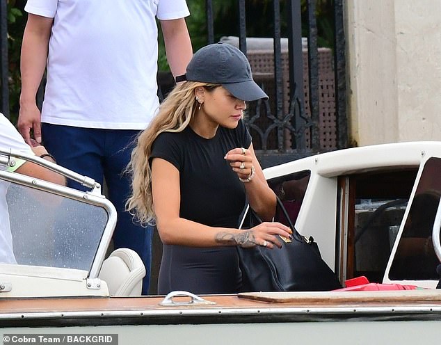 Trendy: The singer showed off her incredible figure in a black top and gray leggings as she boarded a taxi boat to travel to Marco Polo Airport